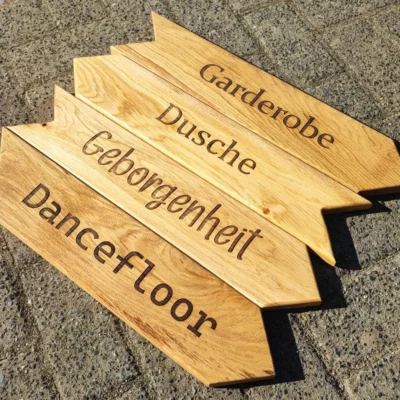 Dekoratives Wegweiserschild aus massivem Eichenholz mit bereits eingravierten Begriffen – Varianten: Garderobe, Dusche, Geborgenheit und Dancefloor. Hochwertig verarbeitetes Holzschild mit natürlicher Maserung, ideal als rustikale Wanddekoration, Beschilderung für Events, Hochzeiten, Partys oder als stilvolles Wohnaccessoire im Flur, Badezimmer oder Wohnzimmer. Handgefertigt, geölt und vorgebohrt zur einfachen Wandmontage – jedes Schild ein Unikat mit langlebiger Gravur und Vintage-Charakter.